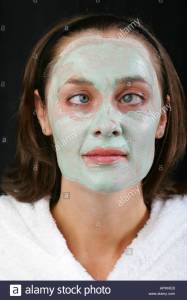 young-woman-with-green-avocado-face-pack-smiles-and-crosses-her-big-apmheb